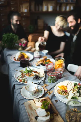 Menschen sitzen am angerichteten Tisch im Café Resonanz.