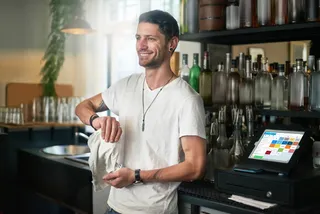 Barkeeper in seiner Bar mit Kassensystem von orderbird