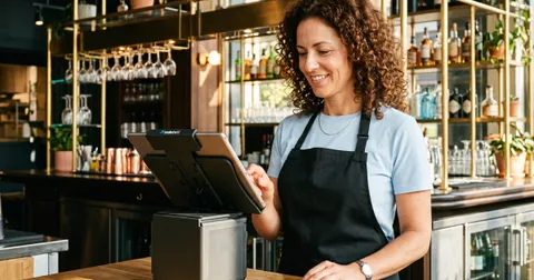 Servicekraft nutzt Kassensoftware in einem Gastronomiebetrieb für die digitale Bestellaufnahme