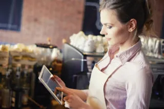 Eine Kellnerin bedient eine iPad-Kasse