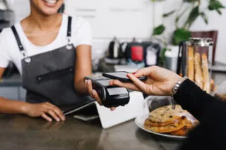 Ein Gast bezahlt in einer Gastronomie mit Apple Pay (kontaktloses Bezahlen via Smartphone)