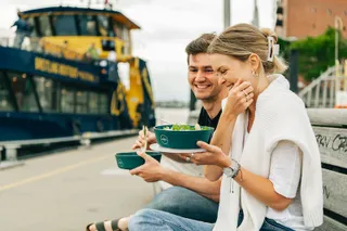 Menschen genießen Essen im Freien aus Mehrwegbehältern