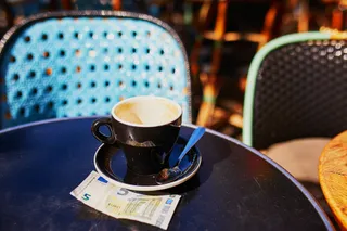 Leere Kaffeetasse auf einem Tisch mit fünf Euro Schein