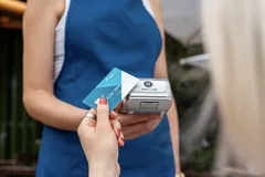 Contactless card payment with card reader in front of a café