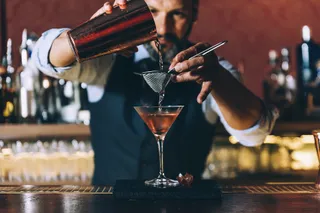 Ein Barkeeper bereitet einen Cocktail zu