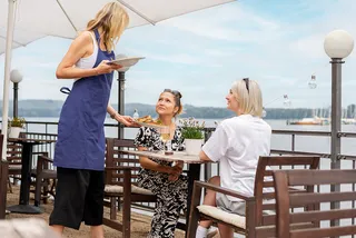 Servicekraft in Restaurant bedient Gäste