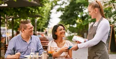 Servicekraft in Gastronomie nimmt Kartenzahlung mit Kartenleser von orderbird entgegen