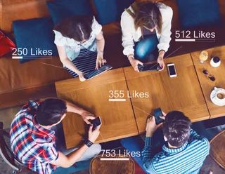 Gäste sitzen in einer Gastronomie und nutzen Facebook Local mit ihren Smartphones
