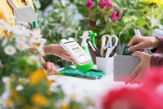 Kunde zahlt am mobilen Kassengerät beim Floristen