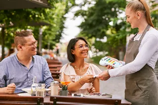 Kunden zahlen im Außenbereich mit Karte bei Service