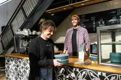 Restaurant Gast holt Essen mit wiederverwendbaren Behältern von RECUP ab