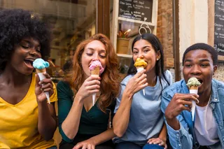 Kunden essen Eis vor Eisladen