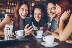 Gäste in einer Gastronomie mit einem Smartphone