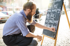 Gastronom schreibt Angebote auf eine Kreidetafel